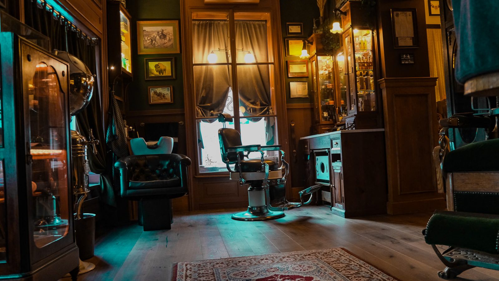 Der Good Old Soul Barbershop mit dunklem Holz, grünen Sesseln und warmem Fensterlicht