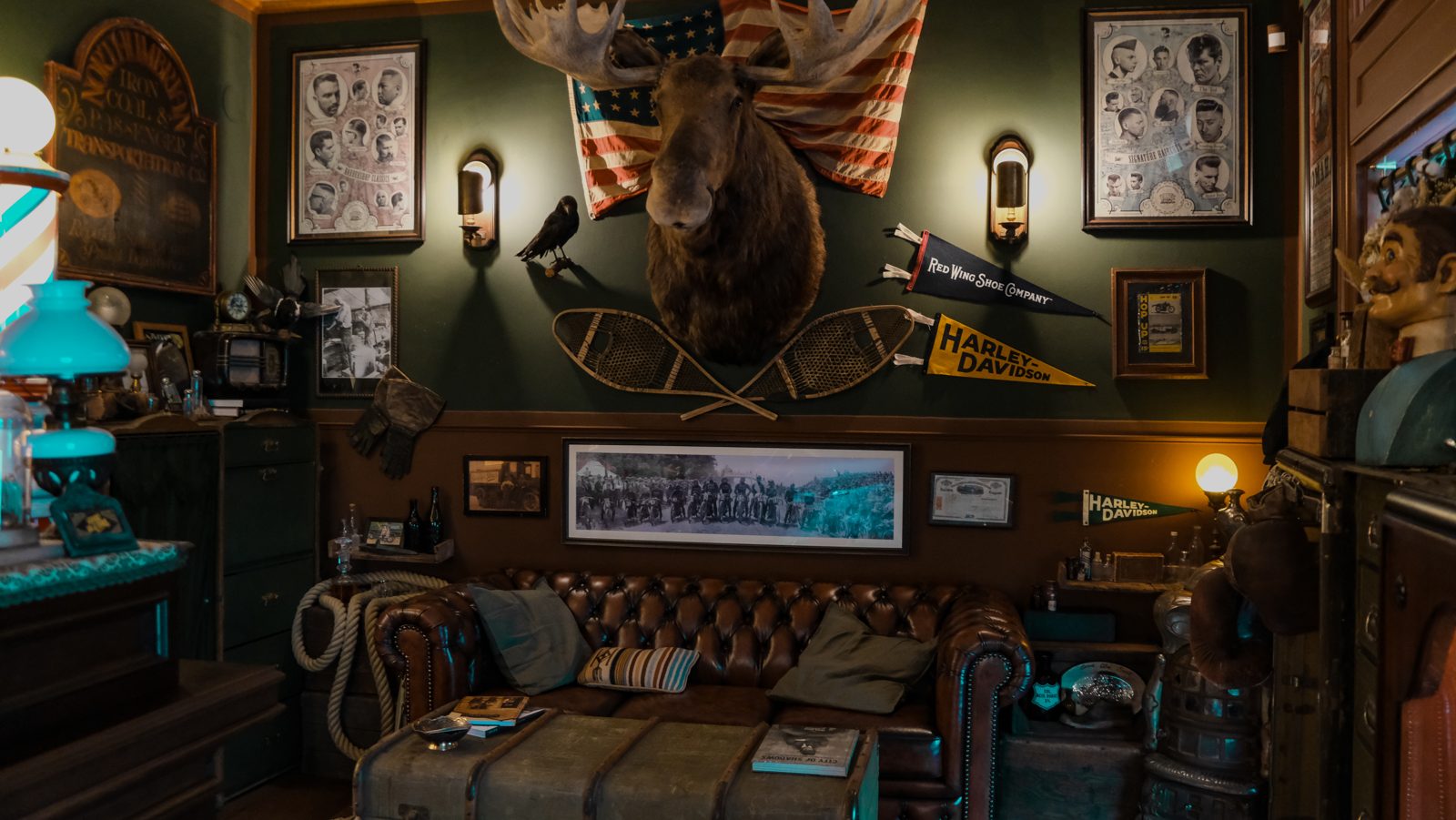 Ledersofa, dunkle Holzwände und Americana-Dekoration im Barbershop